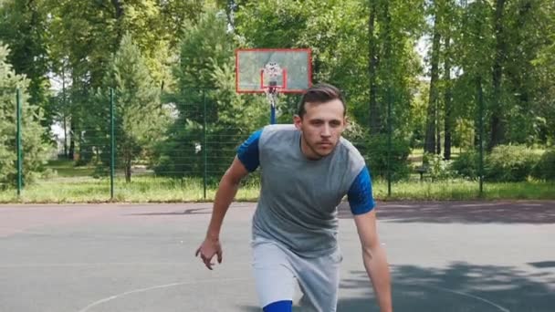 Όμορφος αθλητής παίζοντας μπάσκετ με δύο φίλους και ντρίμπλα με το ένα χέρι — Αρχείο Βίντεο