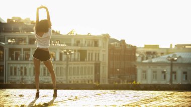 Yüksek topuklu genç bir çekici kadın elleri havada ayakta