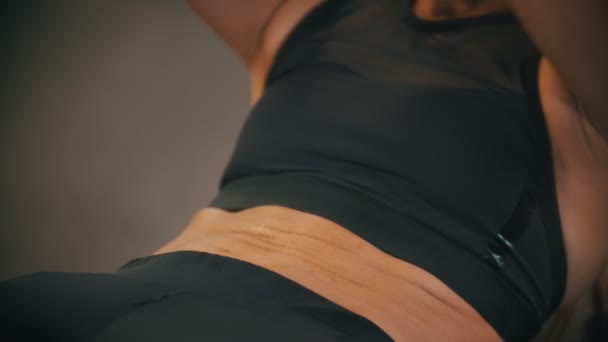 Una donna atleta che si allena in palestra - pompando i muscoli addominali - suda sulla pancia — Video Stock