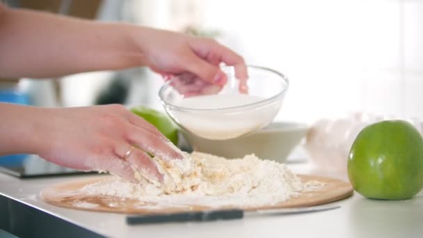 Ręka kobiety dodając mąkę do ciasta i kontynuować ugniatanie go — Wideo stockowe