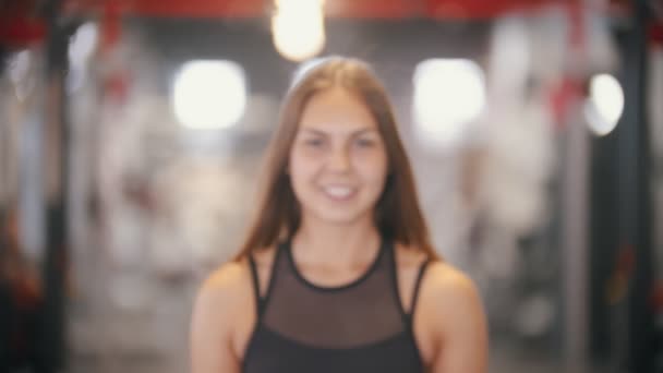Μια αθλήτρια χαμογελαστή γυναίκα που πίνει νερό στο γυμναστήριο — Αρχείο Βίντεο