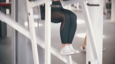 Spor salonunda egzersiz bir atlet kadın - kollarını eğilerek ve kendine bacaklarını çeker