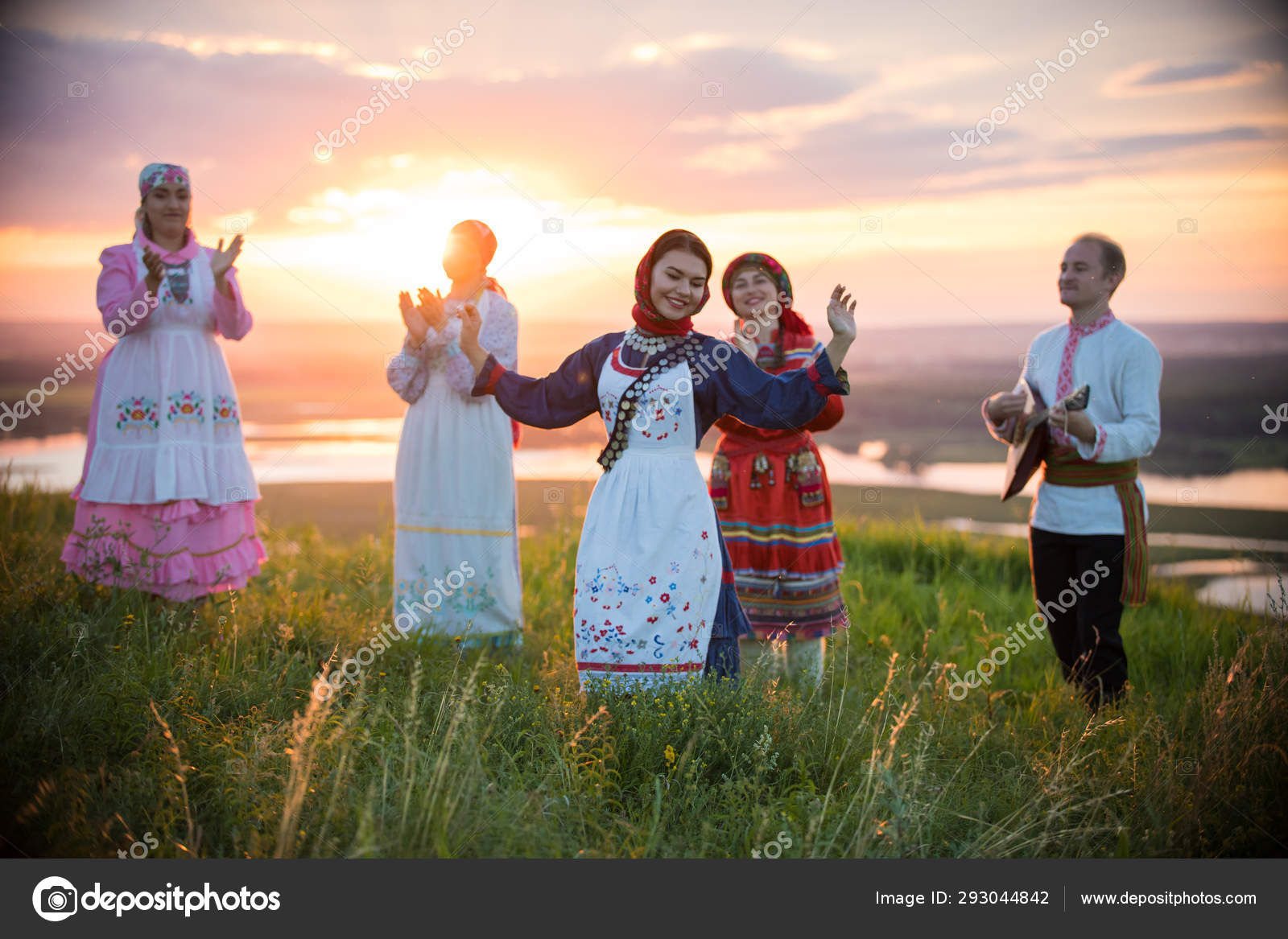 Young smiling woman in traditional russian clothes stands on a