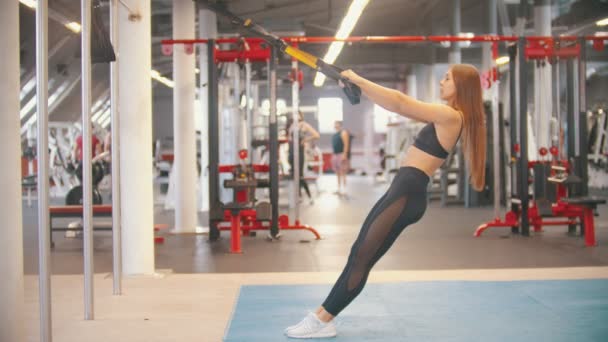 Une femme sportive en tenue de sport s'entraînant dans la salle de gym - penchée vers l'arrière tenant les poignées — Video