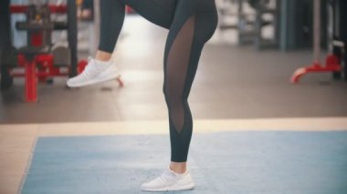 Spor salonunda sportif bir kadın eğitim - kolları tutarak ve diz aşağı yapıyor