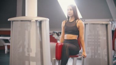 Spor salonunda uzun saç eğitimi ile bir atlet kadın - kelebek eğitim aparatı üzerinde egzersiz