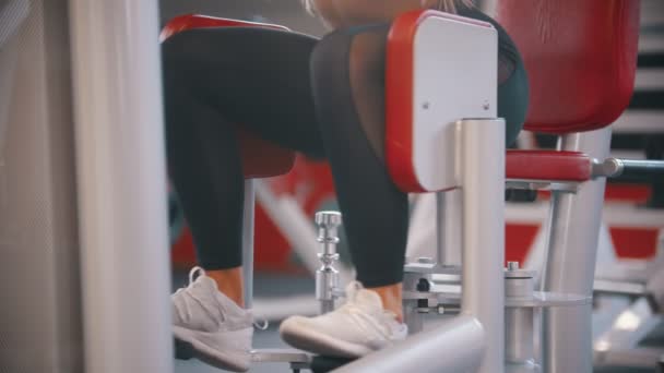 Una mujer entrenando en el gimnasio - ejercitándose en el aparato de entrenamiento de mariposas — Vídeo de stock