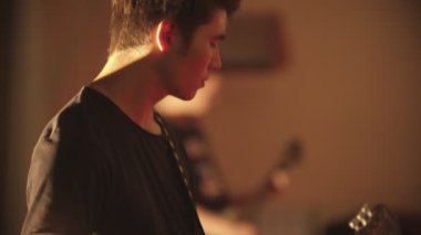 Konserde elektro gitar çalan bir adam.