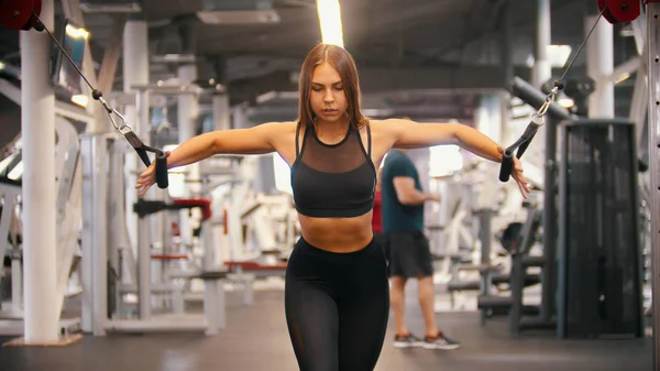Eine sportliche Frau, die im Fitnessstudio trainiert - Griffe ziehen - Hände trainieren — Stockfoto