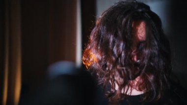 Uzun saçlı genç bir adam onun performansında bir şarkı söyleyerek bitmiş - saçlarını geri atar ve kalabalığa bakarak