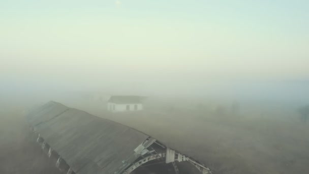 Edifícios abandonados num campo vazio no nevoeiro — Vídeo de Stock