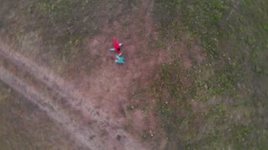 Parlak giysiler içinde genç bir çift el ele tutuşarak sahada dans