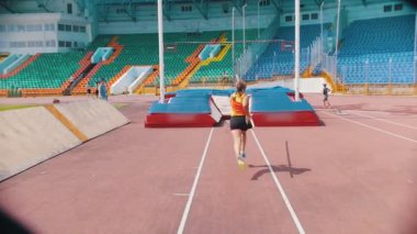 Pole vault - Genç bir atletik kadın bar üzerinden atlar - stadyum açık