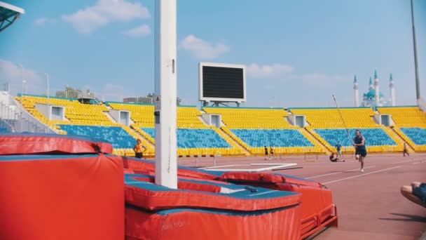 Stavhopp-en skäggiga atletisk man springer upp håller en stolpe och hoppar — Stockvideo