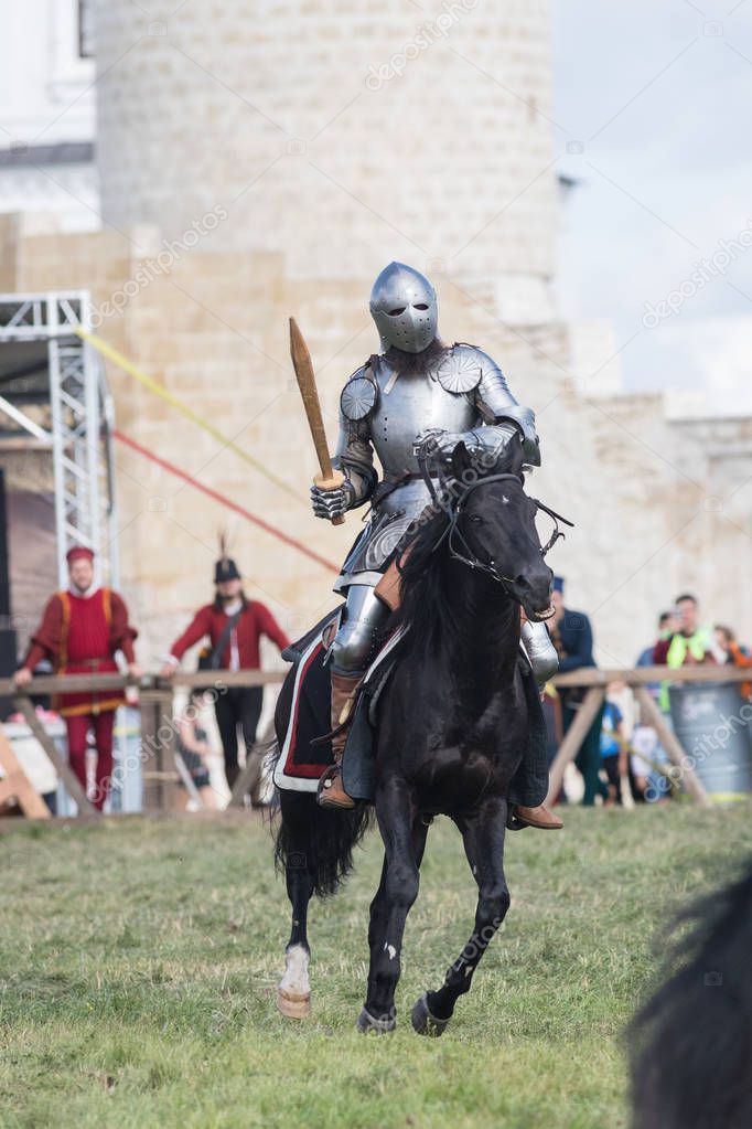 A man knight riding a horse holding a wooden sword