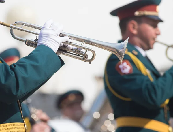 Una sfilata di strumenti a fiato - un uomo in costume verde che suona la tromba — Foto Stock