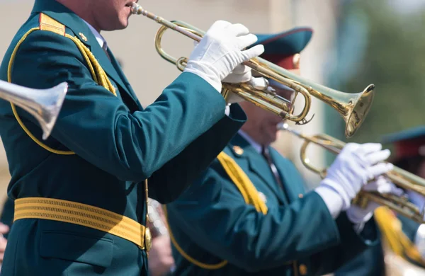 Una sfilata di strumenti a fiato - uomini in costume verde che suonano la tromba — Foto Stock