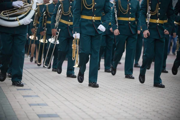 Una sfilata di strumenti a fiato - gente in costume verde che marcia — Foto Stock