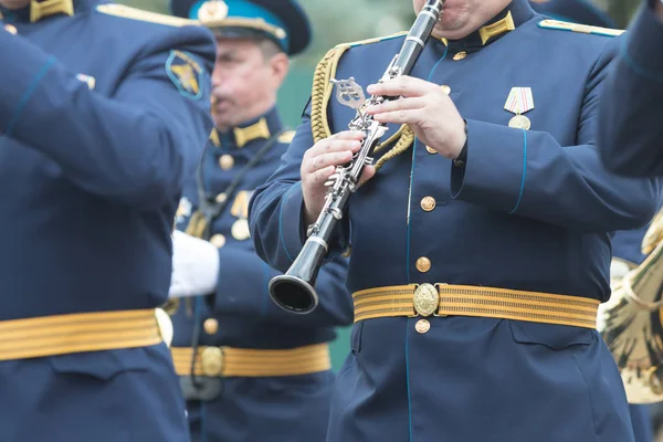 Una parata di strumenti a fiato - un uomo in costume blu che suona il clarinetto — Foto Stock