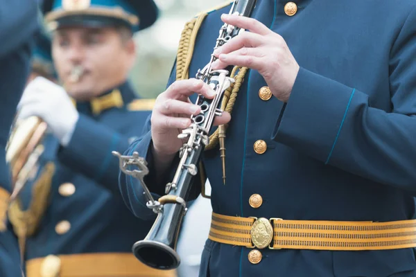 Una sfilata di strumenti a fiato - un uomo in costume blu che suona il clarinetto al festival — Foto Stock