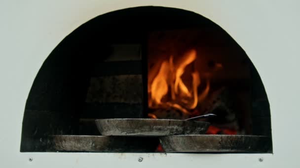 Un horno encendido y calentado con fuego en el interior - tres sartenes de pie en el borde del horno — Vídeos de Stock