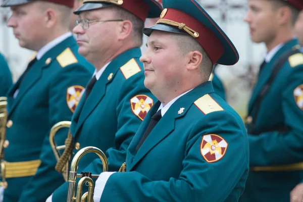 RUSSIA, KAZAN 09-08-2019: A wind instrument parade - people in green costumes standing on the street holding musical instruments - a chubby man smiling — Stock Photo, Image