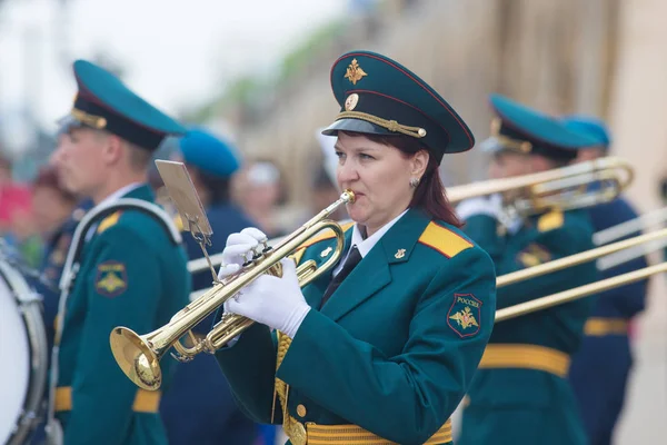 Russland, kasan 09-08-2019: eine blasinstrumentenparade - eine frau im grünen kostüm trompetet — Stockfoto