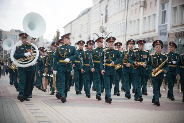 RUSSIA, KAZAN 09-08-2019: Una sfilata di strumenti a fiato - persone in costume verde che camminano per strada con diversi strumenti musicali — Foto Stock