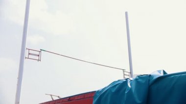 Pole vault eğitim - bir kadın başarıyla bar üzerinden atlama ve paspas üzerine düşüyor