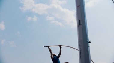 Dışında stadyumda Pole vault eğitim- bir atletik adam bar üzerinden atlama ve bar ile aşağı düşen - başarısız girişimi