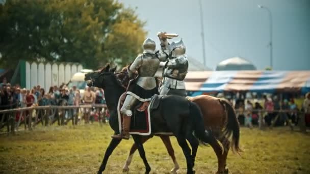 Булгар, Росія 11-08-2019: Лицарі, що мають битву на дерев'яні мечі на полі-люди дивляться позаду паркан-середньовічний фестиваль — стокове відео