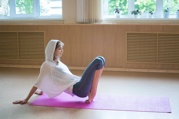 Jonge vrouw ballerina staat op haar tip tenen op de yoga mat-dansstudio — Stockfoto
