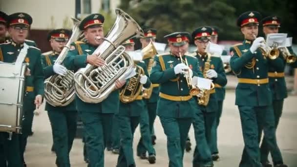 Росія, Казань 09-08-2019: вітер інструмент парад-військові музиканти в зелених костюмах ходьба по вулиці Холдинг музичні інструменти — стокове відео