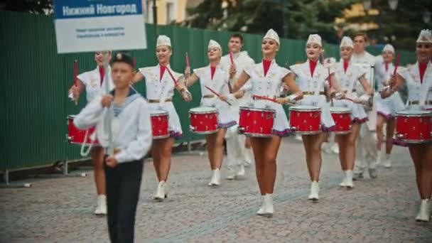 RUSIA, KAZAN 09-08-2019: Un desfile militar de instrumentos de viento - mujeres con maquillaje brillante en faldas pequeñas tocando tambores rojos - Nizhny Novgorod conjunto de majorettes y bateristas — Vídeo de stock