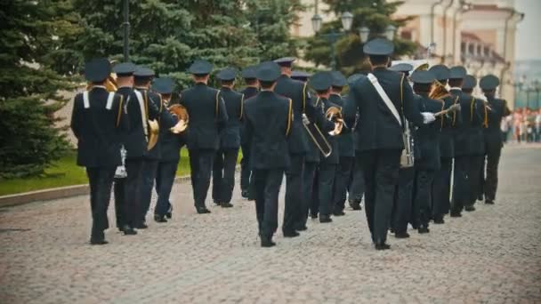 RUSIA, KAZAN 09-08-2019: Un desfile de instrumentos de viento - músicos militares con disfraces negros marchando por la calle sosteniendo instrumentos musicales — Vídeo de stock