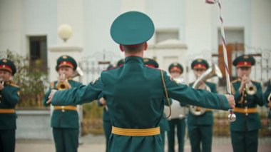 Rusya, Kazan 09-08-2019: Bir rüzgarlı enstrüman geçit töreni - yeşil kostümlü insanlar kapellmeister dinlerken