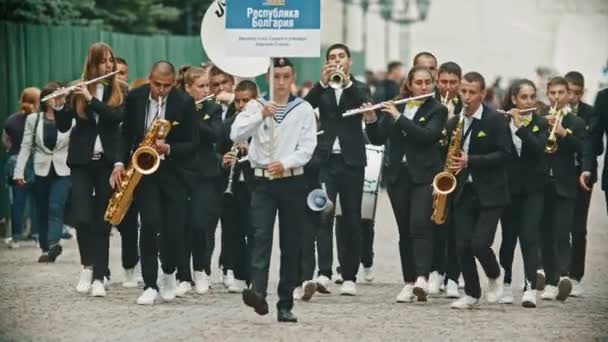 RUSSIE, KAZAN 09-08-2019 : Un défilé d'instruments à vent - adolescents et enfants marchant dans la rue - Plaque signalétique Bulgarie — Video