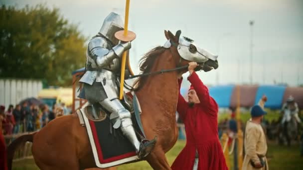 BULGAR, RUSSIA 11-08-2019: a man assistant holding back the horse with a knight riding it - the horse breaks through — Stock Video