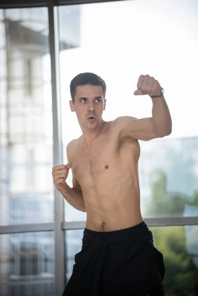 Un boxeador atlético de pie en pose de lucha en el estudio —  Fotos de Stock