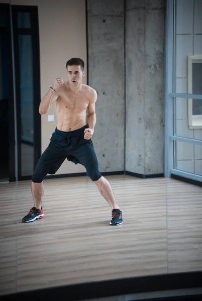 Um homem atlético boxeador treinando no estúdio brilhante — Fotografia de Stock
