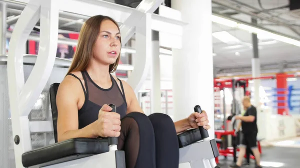 Een atleet fit vrouw training in de sportschool-het uitvoeren van een been trainen van apparatuur — Stockfoto