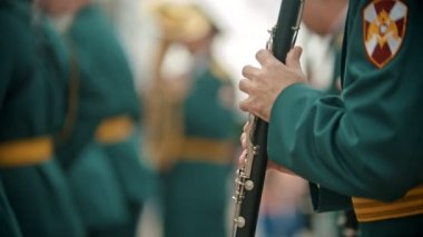 Bir rüzgarlı enstrüman askeri geçit töreni - festivalde klarnet çalan yeşil kostümlü bir adam