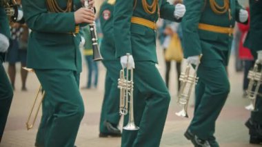 Bir rüzgarlı enstrüman askeri geçit töreni - yeşil kostümleri insanlar sokakta aletleri tutarak yürüyüş
