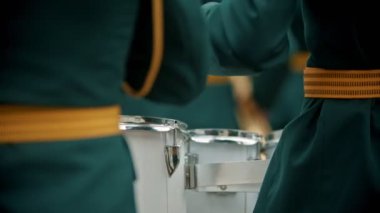 Bir rüzgarlı enstrüman askeri geçit töreni - yeşil kostümleri insanlar açık havada davul çalıyor