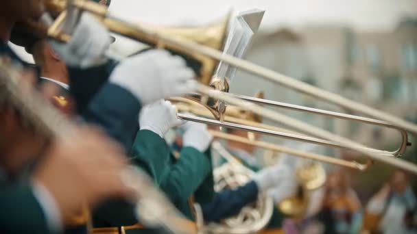 Een blaasinstrument militaire parade-mannen in kostuums spelen trompetten en trombone buitenshuis — Stockvideo