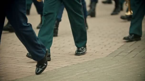 Un desfile militar de instrumentos de viento al aire libre - personas con trajes verdes marchando en la calle sosteniendo instrumentos — Vídeos de Stock