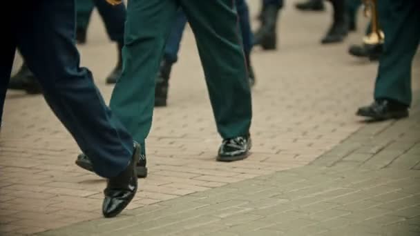 Un desfile militar de instrumentos de viento al aire libre - personas con trajes verdes marchando en la calle sosteniendo instrumentos — Vídeo de stock