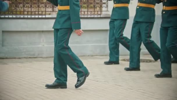 Un desfile de instrumentos de viento - gente con trajes verdes en gorras caminando por las calles — Vídeo de stock