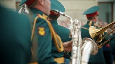 Bir rüzgarlı enstrüman askeri geçit töreni - yeşil kostümleri insanlar sokakta yürüyüş ve enstrümanlar çalıyor