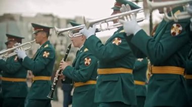 Rusya, Kazan 09-08-2019: Bir rüzgarlı enstrüman askeri geçit töreni - açık havada trompet çalan yeşil kostümlü bir adam